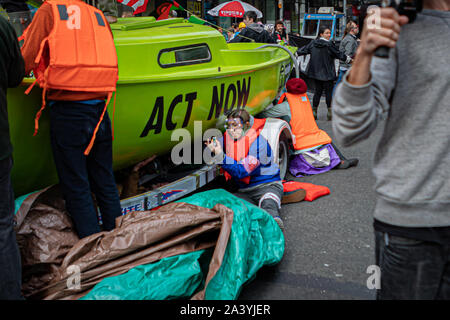 New York City, USA. 10 Okt, 2019. Klima Aktivisten angeschlossen mit der globalen Umwelt Gruppe? Aussterben Rebellion' inszeniert eine gewaltfreie Akt zivilen Ungehorsams' in der Mitte des Times Square, Sperrung des Verkehrs für etwa eine Stunde. Die Demonstranten ein Lime Green Boot an der Kreuzung von Broadway und 44th Street geparkt, das Schiff umgeben und fuhr fort, sich Kette zu Sekundenkleber. Entsprechend der NYPD, 62 Demonstranten wurden festgenommen. (Foto von Michael Nigro/Pacific Press) Quelle: Pacific Press Agency/Alamy leben Nachrichten Stockfoto