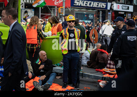 New York City, USA. 10 Okt, 2019. Klima Aktivisten angeschlossen mit der globalen Umwelt Gruppe? Aussterben Rebellion' inszeniert eine gewaltfreie Akt zivilen Ungehorsams' in der Mitte des Times Square, Sperrung des Verkehrs für etwa eine Stunde. Die Demonstranten ein Lime Green Boot an der Kreuzung von Broadway und 44th Street geparkt, das Schiff umgeben und fuhr fort, sich Kette zu Sekundenkleber. Entsprechend der NYPD, 62 Demonstranten wurden festgenommen. (Foto von Michael Nigro/Pacific Press) Quelle: Pacific Press Agency/Alamy leben Nachrichten Stockfoto