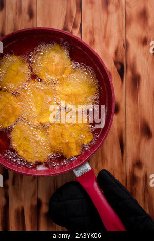 Frittierte Bananen frittierte in einem roten Pfanne Stockfoto