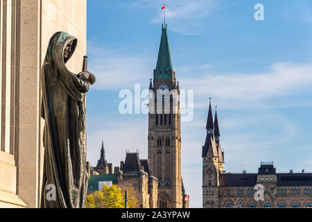 Ottawa, CA - 9. Oktober 2019: Statue Ivstitia (Gerechtigkeit) vor der Oberste Gerichtshof von Kanada mit kanadischen Parlament im Hintergrund. Stockfoto