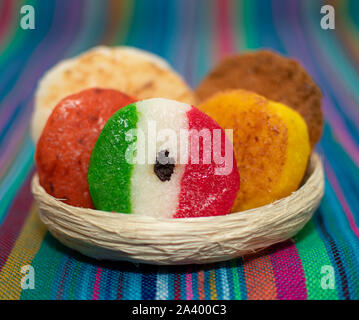 Korb mit einer Reihe von typischen mexikanischen Kokosnuss Bonbons Honig cocada traditionelle mexikanische Flagge Teppich Hintergrund Farben sarape mexikanischen Stockfoto