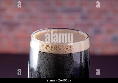 Eine dunkle Irische trocken Stout Bier Glas Nähe zu sehen. Stockfoto