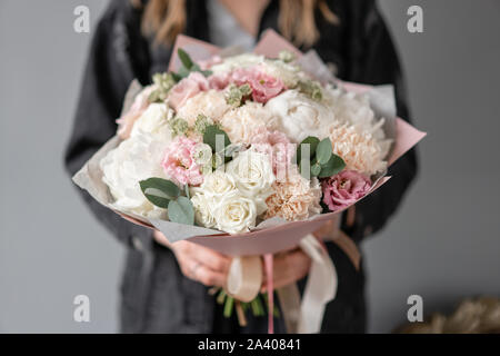 Kleiner schöner Blumenstrauß aus gemischten Blumen in der Frau die Hand. Blumen Shop Konzept. Blumen Lieferung. Weiße Pfingstrosen Stockfoto