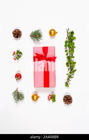 Kreative flach winter Spielzeug, Beeren, Äpfel, Kugeln, Kegel und umhüllt mit Schleife Geschenk auf weißem Hintergrund. Flach. Urlaub Kollektion. Stockfoto
