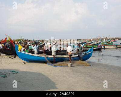 Indien, Kochin - April 06, 2019: Fischer und Fischerbooten. Fischer Netze entwirren Stockfoto