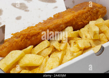 Fisch und Chips in einem Karton von einem Takeaway. Recycling der Verpackung. Graues Holz Hintergrund Stockfoto