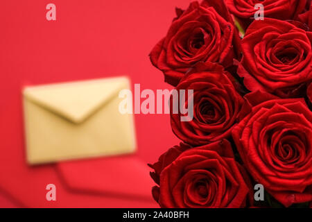 Urlaub Geschenk, Blumen flatlay und glückliche Beziehung Konzept - Brief Liebe und Blumen Lieferservice am Valentinstag, Luxus Strauß roter Rosen Stockfoto