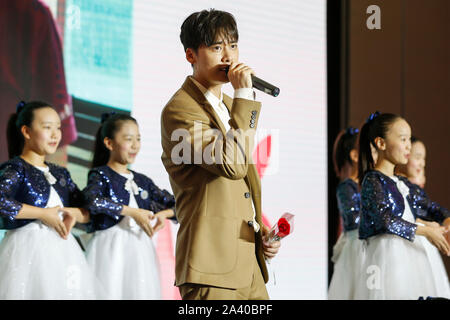 (191028) - Peking, Oktober 11, 2019 (Xinhua) - Li Yifeng (C), ein Förderer der Feder Bud Projekt singt ein Lied auf einer Pressekonferenz über die Ergebnisse der Frühling Knospe Projekt in Peking statt, der Hauptstadt von China, Okt. 10, 2019. Die Feder Bud-Projekt, das von der China Kinder und Jugendliche "Fonds (CCTF) im Jahr 1989 ins Leben gerufen, finanziert, und half über 3,69 Millionen arme Mädchen in den letzten 30 Jahren. Das Programm dabei helfen, den armen Mädchen, die Schule zu beenden, hat gesammelten Spenden im Wert von fast 2,12 Milliarden Yuan (rund 297,5 Millionen US-Dollar) und Unterstützung für den Aufbau von 1, Stockfoto
