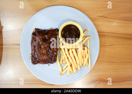 Rippchen oder gegrilltem Schweinefleisch oder Gegrilltes vom Schwein mit Pommes frites Stockfoto