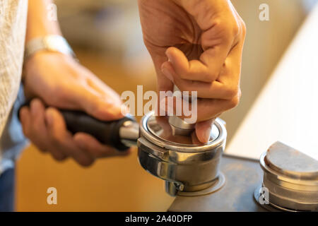 Schritt für Schritt und Teil Vier. Stopfen von den gemahlenen Kaffee in der Gruppe griff oder portafilter Die richtige Dichte für die Extraktion proc zu gewährleisten Stockfoto