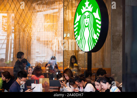 Kunden an einem amerikanischen Kaffee und Kaffeehaus Kette Starbucks Stores in Shenzhen. Stockfoto