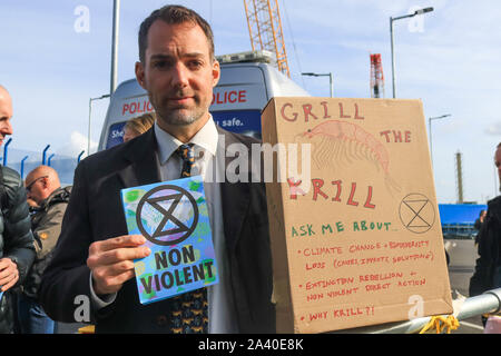 Ein Klima Aktivist Demonstrant hält eine Broschüre als Aussterben rebellion Demonstranten versuchen Sie die London City Airport für drei Tage zu schließen. Stockfoto