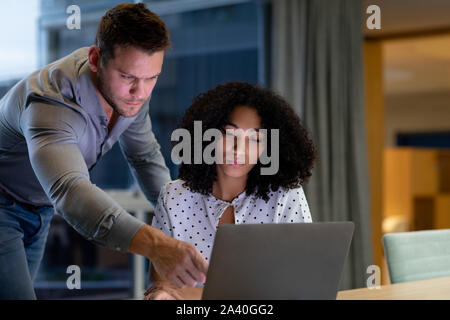 Zwei junge kreative Fachleute, die spät in einem modernen Büro Stockfoto