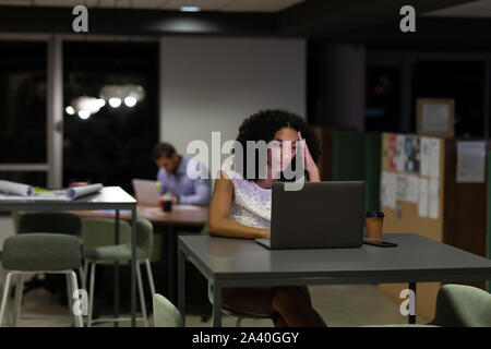 Zwei junge kreative Fachleute, die spät in einem modernen Büro Stockfoto