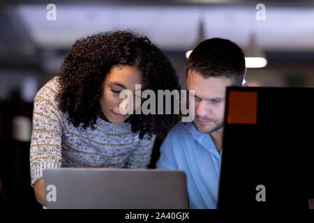 Zwei junge kreative Fachleute, die spät in einem modernen Büro Stockfoto