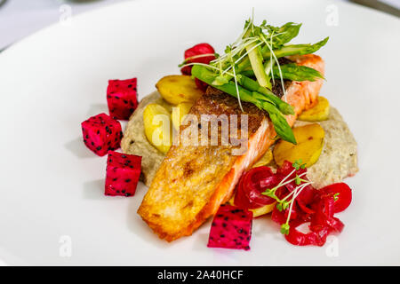 Knusprige gehäutet Atlantischen Lachs mit gebratenen Kartoffeln, sautierten Spargel und Baba ghanoush, mit Sojasprossen und Drachenfrucht eingerichtet. Ansicht von oben Stockfoto