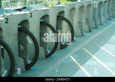 Reihe der abgestellte Fahrräder zum Mieten auf dem Bürgersteig. In der Nähe der Räder in der europäischen Stadt. Stockfoto