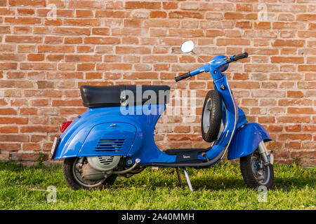 Alte blaue Vespa auf grünen Rasen in Rom, Italien, geparkt. Stockfoto