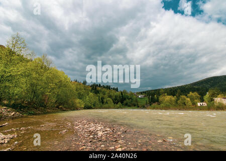 Fluss in den Bergen. Die schöne Landschaft der Karpaten in der Ukraine. Jaremtsche. Gewitterwolke, Gewitterwolken. Reisen Hintergrund. Pinienwald Pinienwald. Stockfoto
