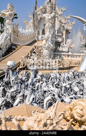 Ein Element des Weißen Tempels/Wat Rong Khun in Chiang Rai, im Norden von Thailand. Viele Hände greifen heraus. Stockfoto