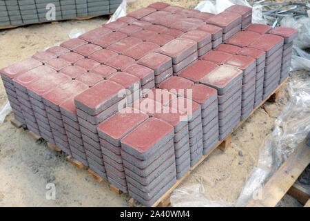 Rote Fliese für den Bürgersteig gefaltet in Blöcken. neue Fliesen Fußgängerweg im Park zu decken. Stockfoto