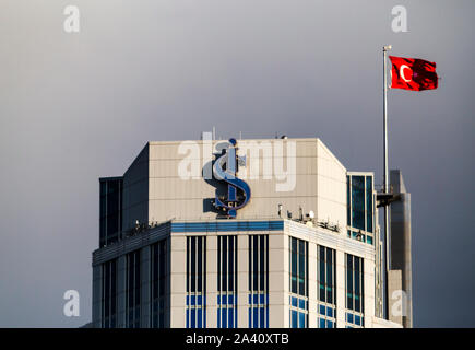 Nahaufnahme der Logo der Isbank mit einem türkischen Flagge auf dem Dach des größten Gebäudes der Türme ist komplex. Stockfoto