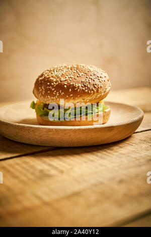 Köstliche Classic Burger auf Holzbrett und schwarzen Hintergrund Stockfoto