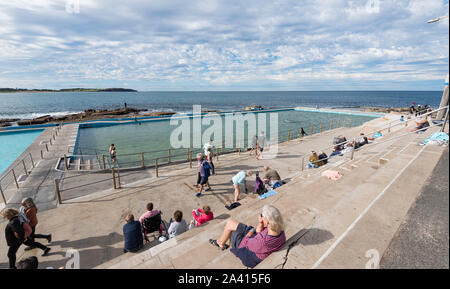 An einem warmen Juni Tag Leute, genießen Sie die Sonne, gehen vorbei und Schwimmen im Solebad am südlichen Ende von Dee Why Beach in Sydney, Australien Stockfoto