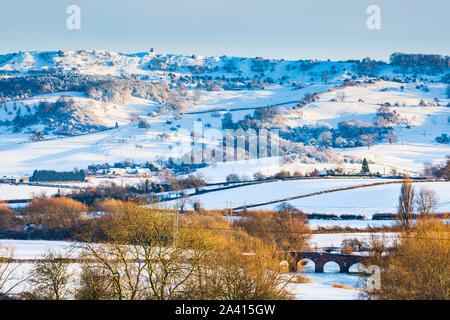 Schneebedeckte Bredon Hügel und Eckington Brücke über den Avon in den Cotswolds AONB, Worcestershire, England Stockfoto