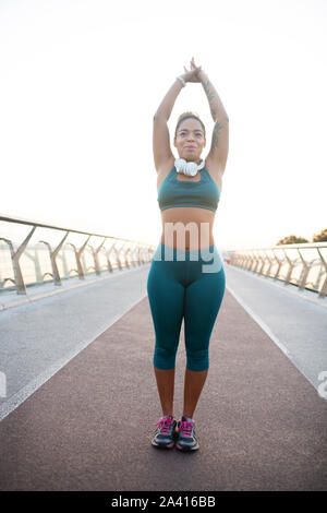 Afro-amerikanische Frau, die ihren Körper Stretching nach dem Lauf Stockfoto