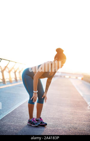 Frau, die kleine Pause während am Morgen läuft Stockfoto