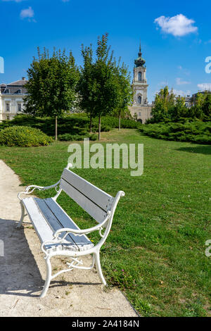 Weiße Bank in einem grünen Park mit Blick auf die schöne barocke Schloss Festetics in Keszthely, Ungarn Stockfoto