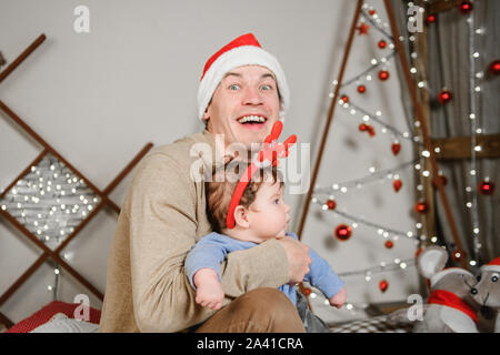 Vater mit seinem Sohn umarmen und Spaß zu haben. Liebe, Glück und das Konzept einer großen Familie. Vater und Sohn viel Spaß im neuen Jahr. Neues Jahr eingerichtet. Stockfoto