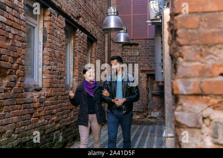 Junges Paar entlang einer alten Gasse und Reden Stockfoto