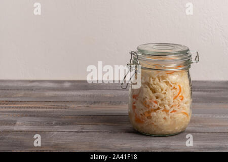 Hausgemachten Sauerkraut mit Karotten in einem Glas auf einer hölzernen braunen Hintergrund. Im rustikalen Stil Stockfoto