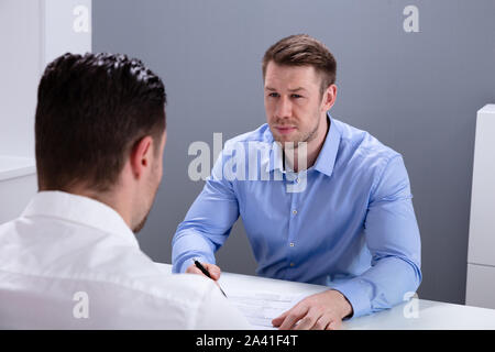 Portrait einer jungen Geschäftsmann in der Diskussion mit seinen Kollegen im Büro Treffen Stockfoto