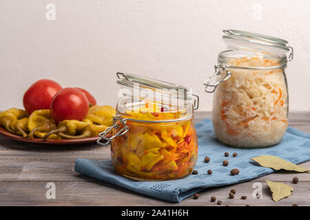 Hausgemachten Sauerkraut in Dosen und Paprika und Tomaten auf einer Keramikplatte auf einer Leinwand Serviette. Im rustikalen Stil Stockfoto