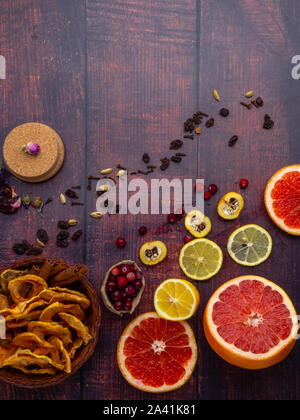 Herbst und Winter Zutaten noch Leben mit grapefruits, Zitronen, Cydonia, Preiselbeeren, Kräuter, getrocknete Äpfel, Zimtstangen, Gewürze, Rosinen auf Holz- ba Stockfoto