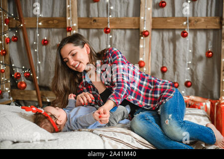 Mutter und Kind liegen auf einer neuen Jahre Bett. Mummys kleiner Junge. Mutter und ihrem Baby zu Hause. Stockfoto