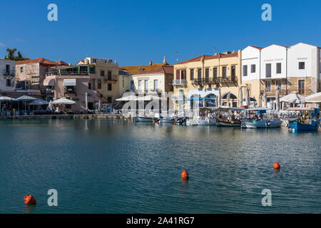 Venezianische Hafen mit kleinen Fischerbooten und Restaurants am Wasser in Rethymno, Kreta Stockfoto