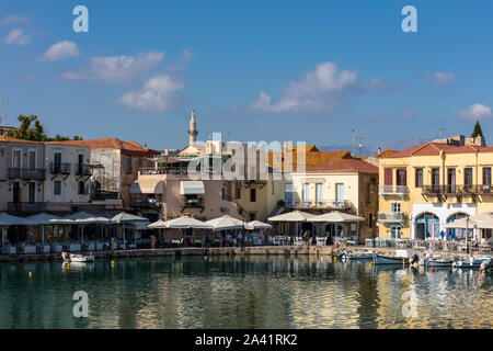 Venezianische Hafen mit kleinen Fischerbooten und Restaurants am Wasser in Rethymno, Kreta Stockfoto