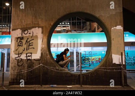 Junge Frau nachts auf der Brücke im Stadtteil Causeway Bay Hong Kong nach Nacht der Gewalt. 29. September 2019. Stockfoto