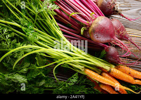 Frische organische Rote Bete und Karotten auf Küche Holz- rustikalen Tisch Nähe zu sehen. Stockfoto