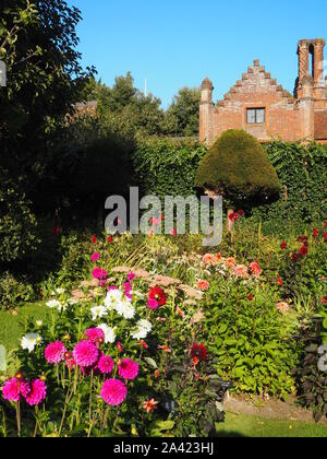 Chenies Manor House an einem Spätsommerabend, versunkene Garten Dahlien, Gras Pfade und Staudenbeet. Stockfoto