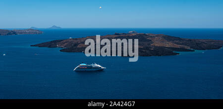 Fira, Griechenland - 12. Juli 2019: ein Kreuzfahrtschiff in der Ägäis verankert Inmitten der vulkanischen Inseln Santorini ab Agiou Mina in Fira gesehen Stockfoto