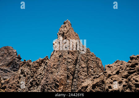 Vulkangestein, geschichteten vulkanischen Felsen in der Wüste mit Berge und blauer Himmel Stockfoto