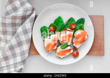 Sandwiches mit roter Fisch auf einem weißen Teller. Mit Grüns dekoriert Stockfoto