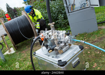 Mann Installation von LWL-Kabel für ultra schnelle Internetverbindung zu einem Wohngebiet Stockfoto