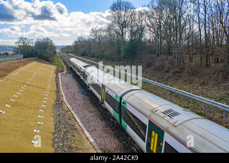 Eine Ansicht aus einem ländlichen Brücke mit Blick auf die Beschleunigung Zug nach Brighton auf der Strecke in Sussex Stockfoto