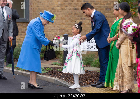 (191028) -- London, Oktober 11, 2019 (Xinhua) - die britische Königin Elizabeth II (L) ist mit Blumen bei einem Besuch in Haig Gehäuse Vertrauen ihre Entwicklung des neuen Gehäuses in London offiziell um die Streitkräfte Veteranen und die Ex-service Community in London, Großbritannien offen präsentiert, am 11.10.2019. Die neue Entwicklung von fast 70 Häuser bieten maßgeschneiderte Unterkunft für schwer Verletzten und behinderten Veteranen. (Foto von Ray Tang/Xinhua) Stockfoto